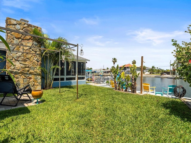 view of yard featuring a water view and a sunroom