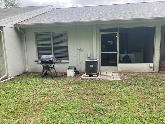 2850 Westmoreland Ct, New Port Richey, FL 34655 - rear view of house featuring central air condition unit, a yard, stucco siding, and roof with shingles