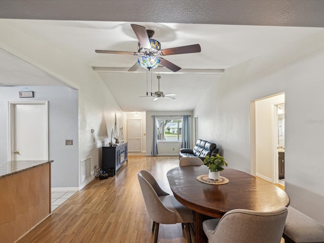 11512 Yellow Birch Ct, New Port Richey, FL 34654 - dining area featuring vaulted ceiling, light wood-type flooring, a wood stove, a ceiling fan, and baseboards