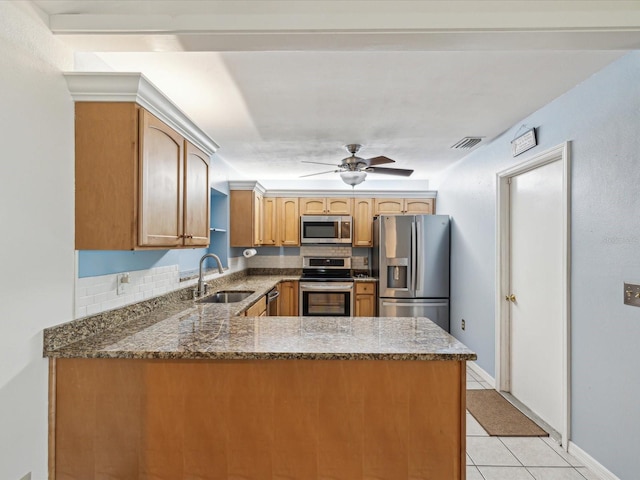 11512 Yellow Birch Ct, New Port Richey, FL 34654 - kitchen featuring appliances with stainless steel finishes, a sink, a peninsula, light tile patterned flooring, and dark stone countertops