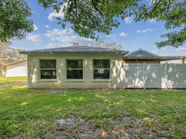 11512 Yellow Birch Ct, New Port Richey, FL 34654 - rear view of property with stucco siding and a yard