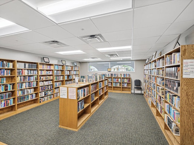 11512 Yellow Birch Ct, New Port Richey, FL 34654 - misc room featuring wall of books, carpet floors, and a paneled ceiling