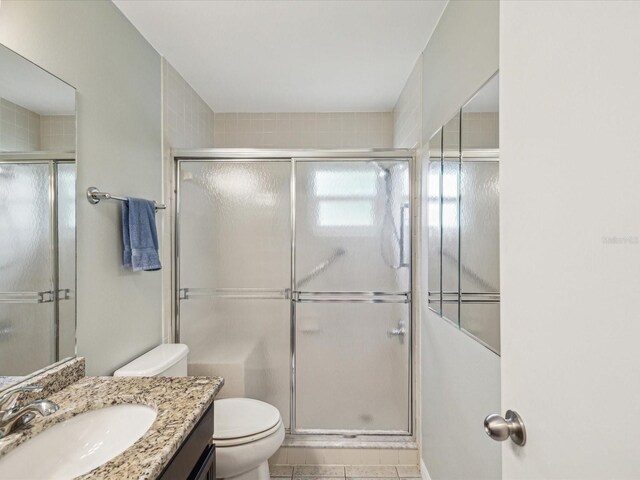 11512 Yellow Birch Ct, New Port Richey, FL 34654 - full bathroom featuring toilet, a shower with door, vanity, and tile patterned floors