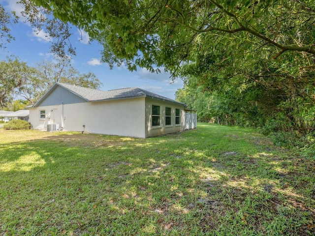 11512 Yellow Birch Ct, New Port Richey, FL 34654 - view of property exterior featuring central AC unit, a yard, and stucco siding