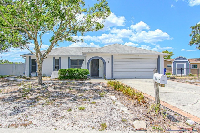 ranch-style house with concrete driveway, an attached garage, stucco siding, and fence