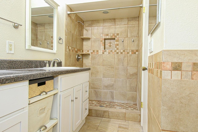 full bathroom featuring vanity and tiled shower
