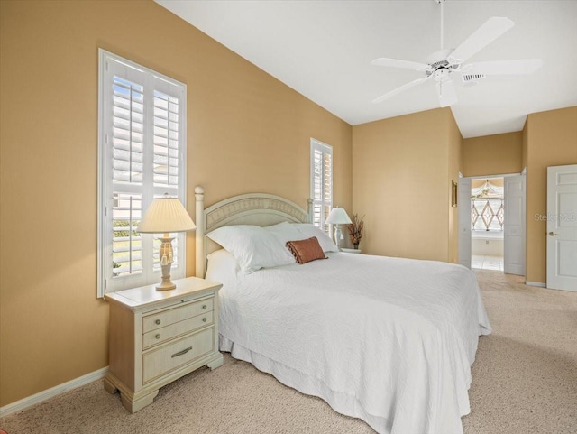 9216 Tarleton Cir, Weeki Wachee, FL 34613 - bedroom with baseboards, ensuite bathroom, ceiling fan, and light colored carpet