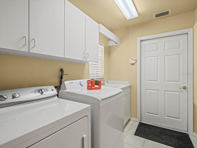 9216 Tarleton Cir, Weeki Wachee, FL 34613 - washroom featuring cabinet space, washing machine and clothes dryer, light tile patterned floors, and visible vents
