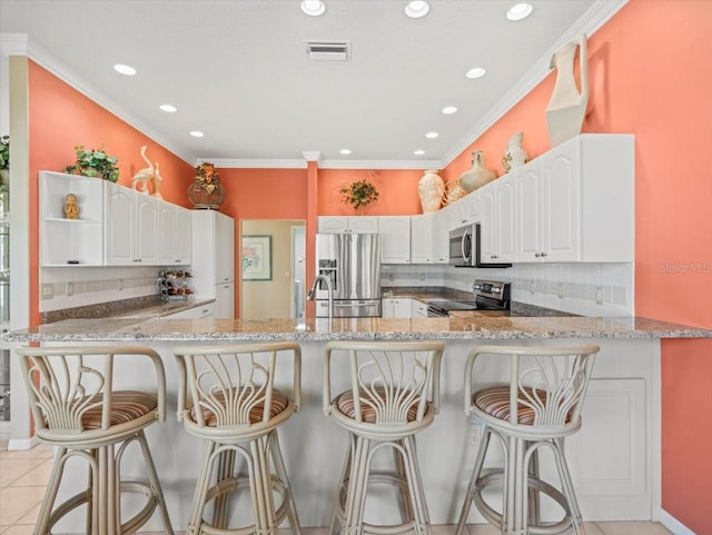 9216 Tarleton Cir, Weeki Wachee, FL 34613 - kitchen with light stone counters, stainless steel appliances, tasteful backsplash, and visible vents