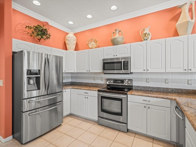 9216 Tarleton Cir, Weeki Wachee, FL 34613 - kitchen featuring ornamental molding, light tile patterned flooring, decorative backsplash, stainless steel appliances, and white cabinets