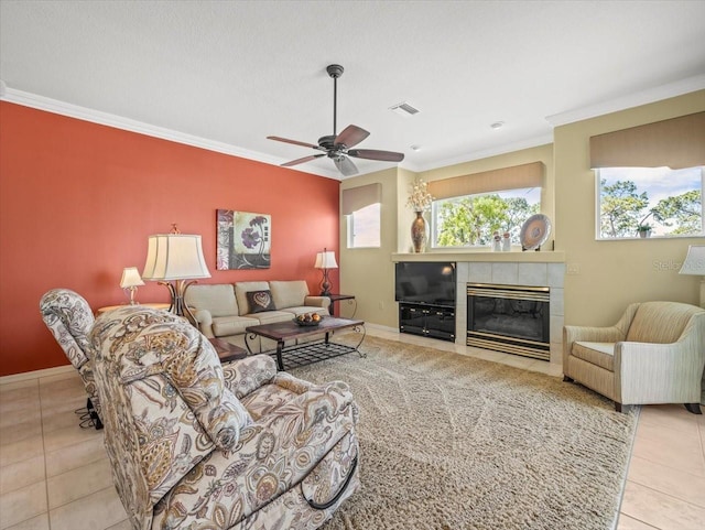 9216 Tarleton Cir, Weeki Wachee, FL 34613 - living area with visible vents, tile patterned flooring, crown molding, ceiling fan, and a tile fireplace
