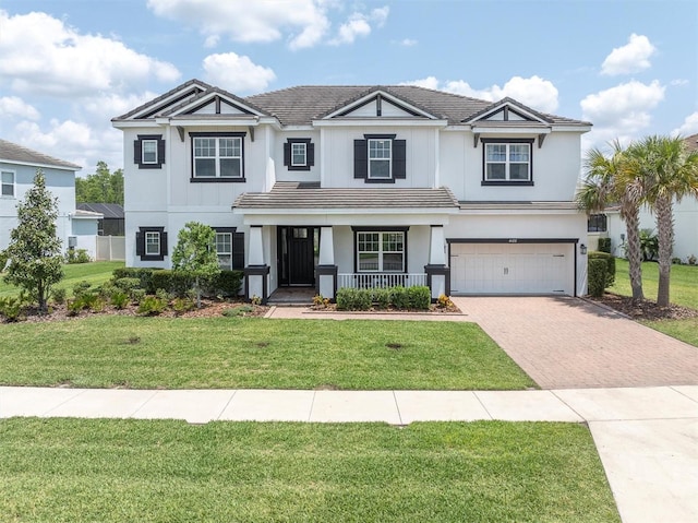 4188 Barbour Trl, Odessa, FL 33556 - view of front of house with decorative driveway, a porch, a garage, a front lawn, and stucco siding