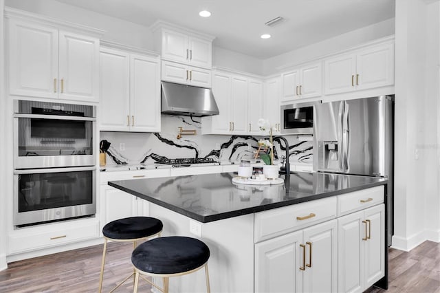 4188 Barbour Trl, Odessa, FL 33556 - kitchen featuring appliances with stainless steel finishes, under cabinet range hood, white cabinetry, dark wood-style floors, and recessed lighting