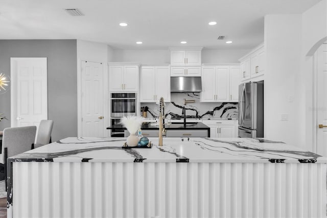 4188 Barbour Trl, Odessa, FL 33556 - kitchen featuring stainless steel appliances, under cabinet range hood, recessed lighting, white cabinets, and light stone countertops