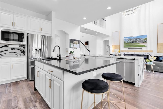 4188 Barbour Trl, Odessa, FL 33556 - kitchen with appliances with stainless steel finishes, arched walkways, a sink, light wood-style floors, and recessed lighting