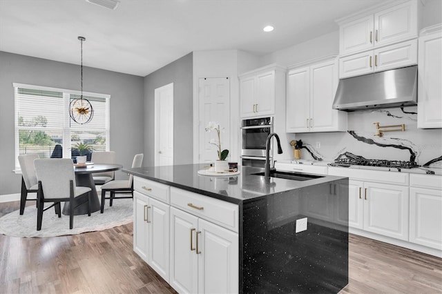 4188 Barbour Trl, Odessa, FL 33556 - kitchen with under cabinet range hood, a sink, stainless steel oven, gas stovetop, and wood finished floors