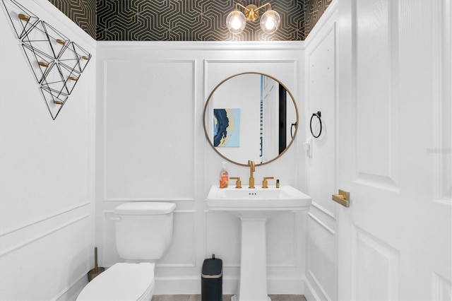 4188 Barbour Trl, Odessa, FL 33556 - bathroom with a decorative wall, toilet, a sink, and wainscoting