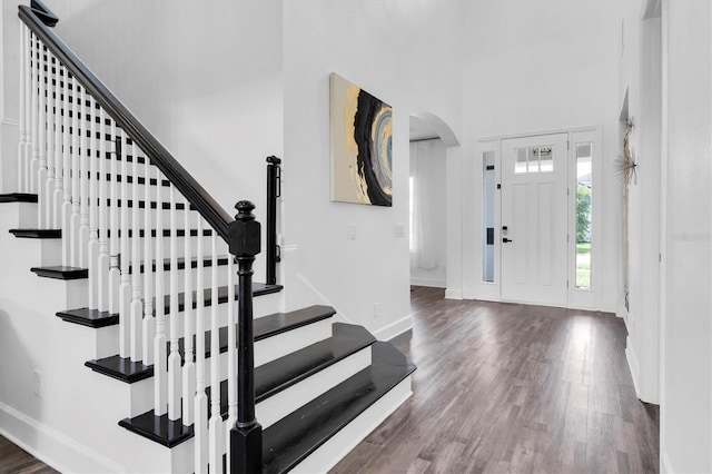 4188 Barbour Trl, Odessa, FL 33556 - foyer entrance with baseboards, a towering ceiling, arched walkways, wood finished floors, and stairs