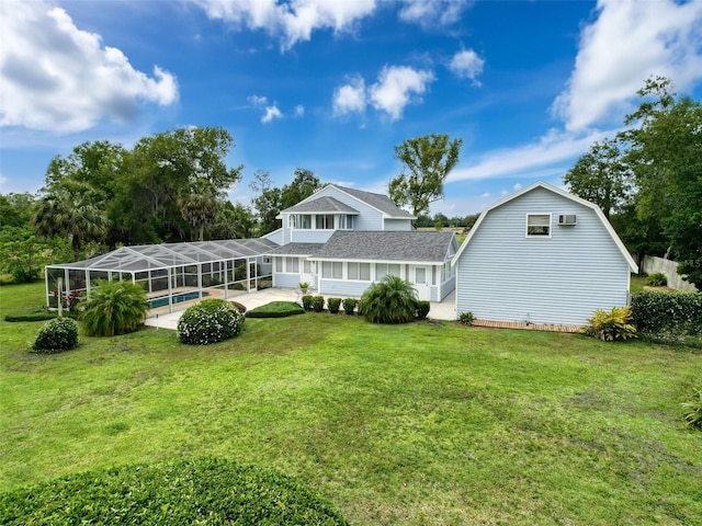 back of property featuring a lawn, an outdoor pool, a patio area, roof with shingles, and a lanai
