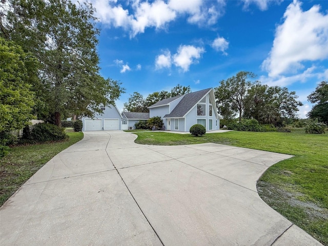 view of front of home featuring concrete driveway, a front yard, and a garage