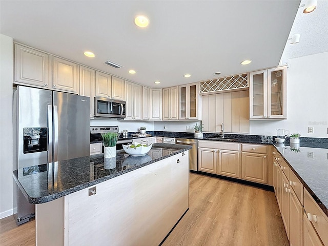 kitchen featuring recessed lighting, a sink, dark stone countertops, stainless steel appliances, and light wood-type flooring