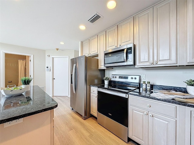 kitchen featuring dark stone countertops, stainless steel appliances, light wood-type flooring, visible vents, and recessed lighting