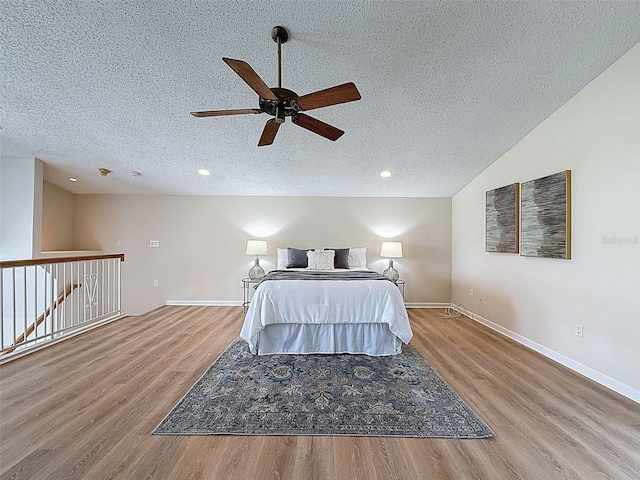 bedroom featuring a ceiling fan, recessed lighting, a textured ceiling, baseboards, and wood finished floors