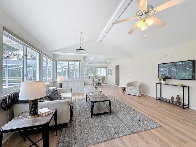 living area with ceiling fan, lofted ceiling with beams, baseboards, and wood finished floors