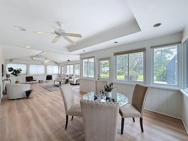 interior space with wood finished floors, a ceiling fan, a raised ceiling, and recessed lighting