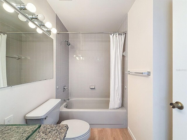 bathroom with toilet, vanity, shower / tub combo, and wood finished floors