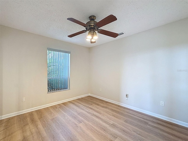 unfurnished room with wood finished floors, baseboards, and ceiling fan