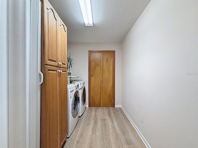 laundry room with light wood finished floors, cabinet space, baseboards, and washer and dryer
