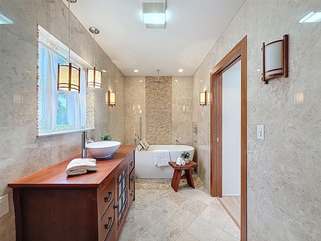full bath with a freestanding bath, tile walls, a walk in shower, and vanity
