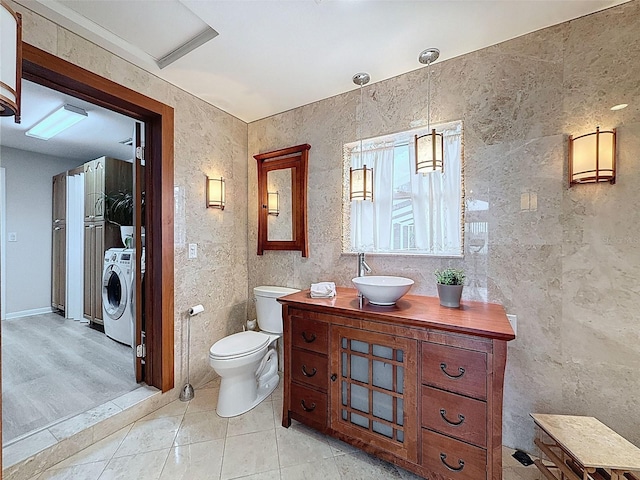 bathroom featuring washer / dryer, toilet, tile patterned flooring, and vanity