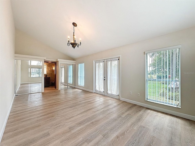 unfurnished living room featuring an inviting chandelier, light wood-style floors, and baseboards