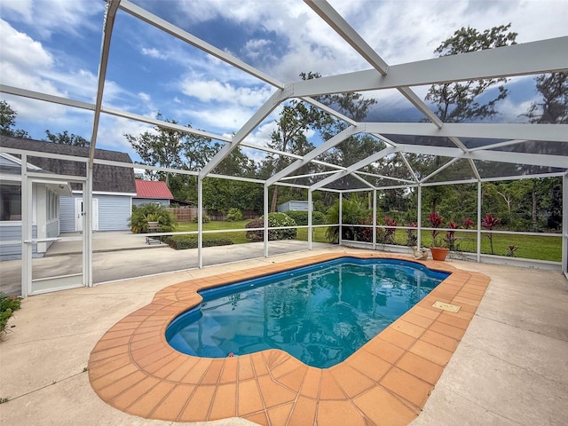 pool featuring glass enclosure, a patio, and an outdoor structure