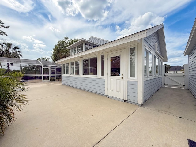 view of side of home with a patio area and a gate