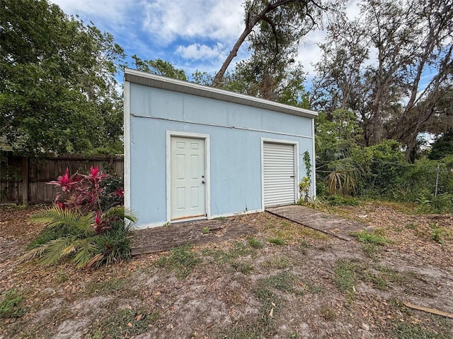 view of outdoor structure featuring an outbuilding and fence
