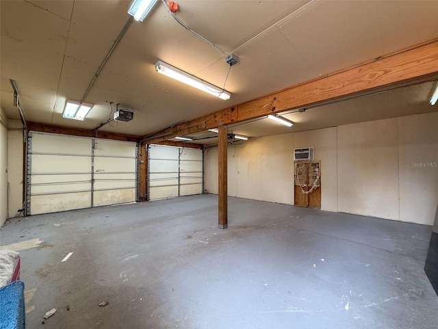 garage featuring an AC wall unit and a garage door opener