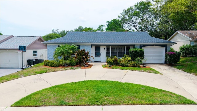 view of front of property with an attached garage, driveway, a front lawn, and central AC