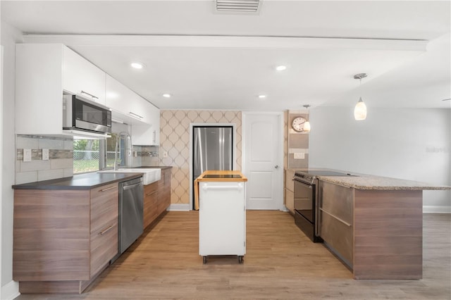 kitchen with appliances with stainless steel finishes, modern cabinets, light wood-style floors, baseboards, and recessed lighting