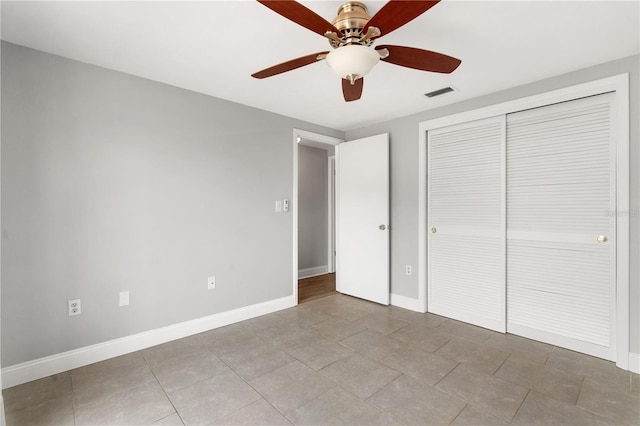 unfurnished bedroom with baseboards, a closet, ceiling fan, and light tile patterned flooring