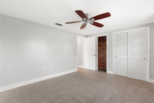 unfurnished bedroom with multiple closets, baseboards, and a ceiling fan