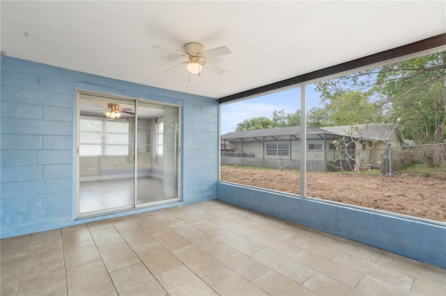 unfurnished sunroom featuring ceiling fan