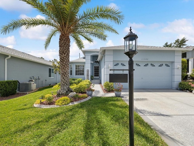single story home with an attached garage, central AC, concrete driveway, and a front yard