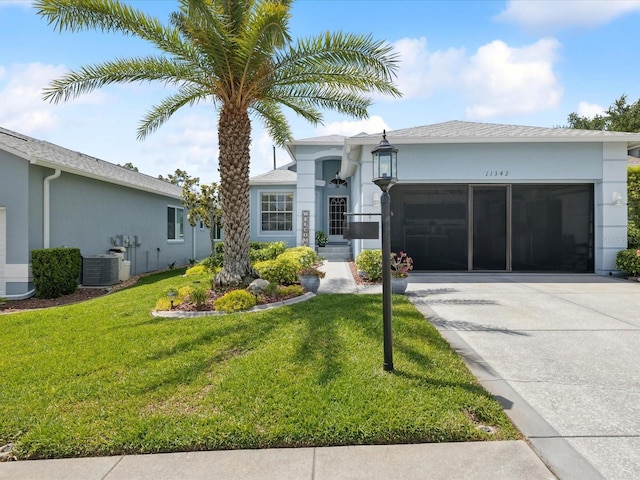 ranch-style home featuring concrete driveway, a garage, stucco siding, and a front lawn