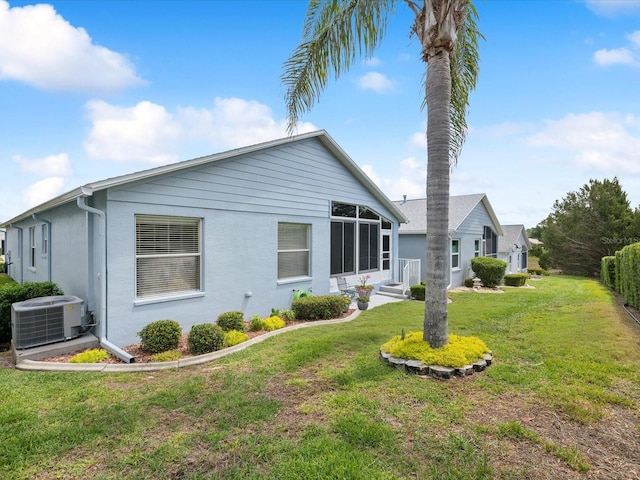 back of house with central AC and a yard