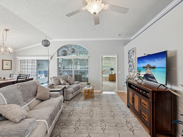 living room with a textured ceiling, ornamental molding, wood finished floors, a ceiling fan, and a chandelier