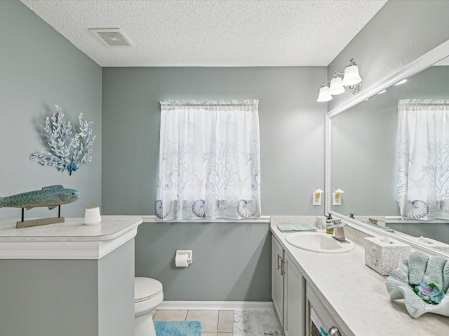 bathroom featuring a textured ceiling, vanity, tile patterned flooring, and toilet