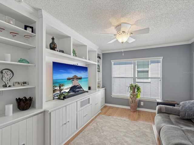 living area with a textured ceiling, light wood-style flooring, a ceiling fan, built in features, and baseboards